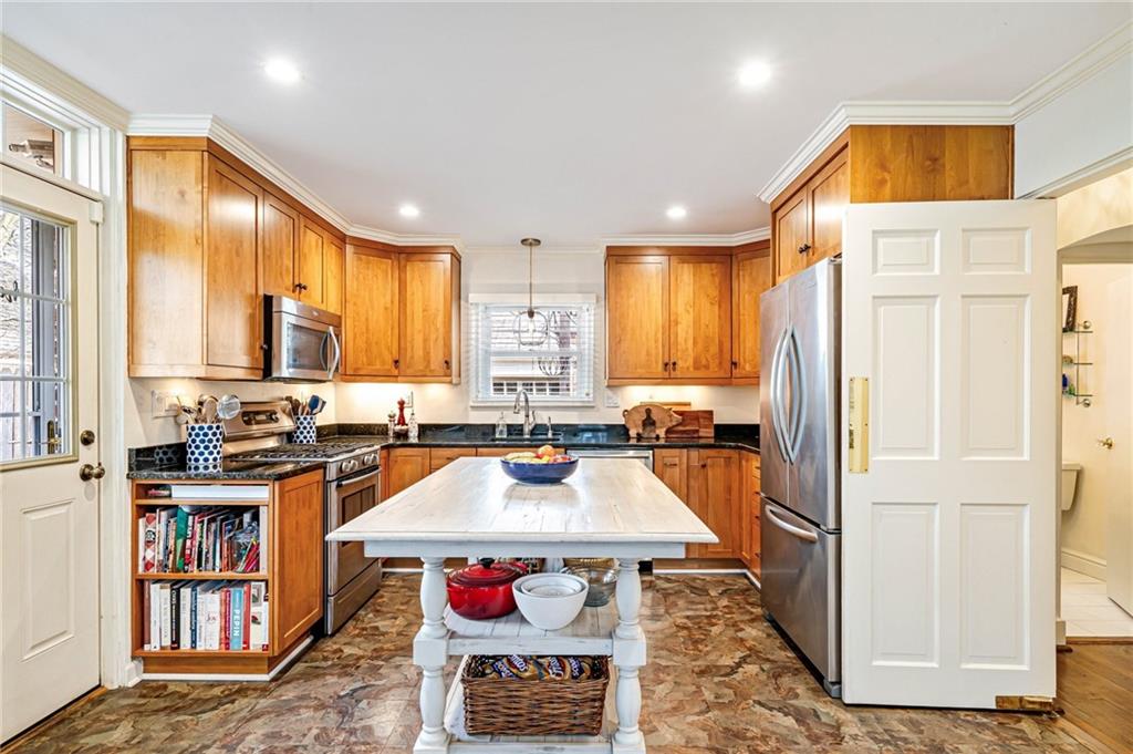 308 Maple Lane Sewickley, PA 15143 - Photo 17 of 40 a kitchen with a refrigerator a stove top oven a sink and a dining table with wooden floor