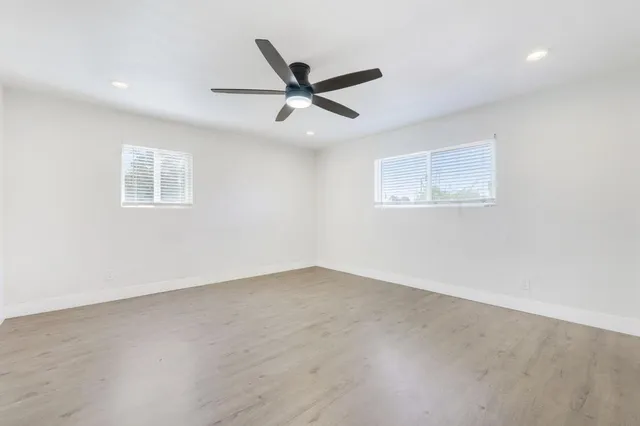 an empty room with a window and a fan