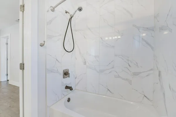 a bathroom with a bath tub with a shower