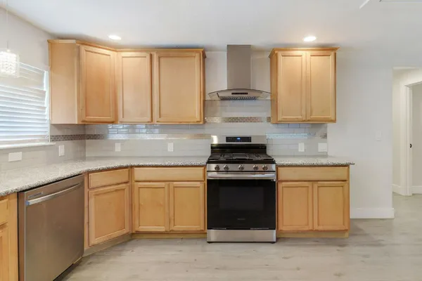 a kitchen with stainless steel appliances granite countertop a stove and a sink