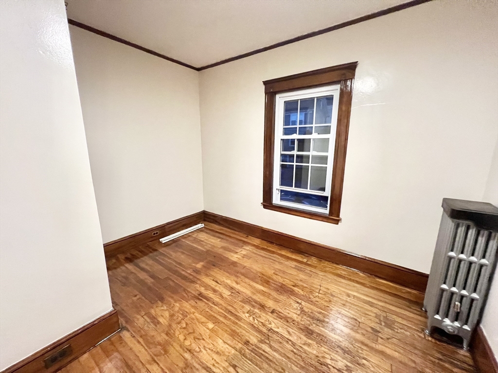 5 City View Road, Unit 2/F Boston, MA 02446 - Photo 11 of 14 a view of an empty room with wooden floor and a window