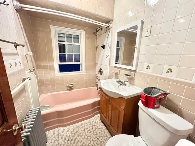 a bathroom with a sink toilet vanity and tub