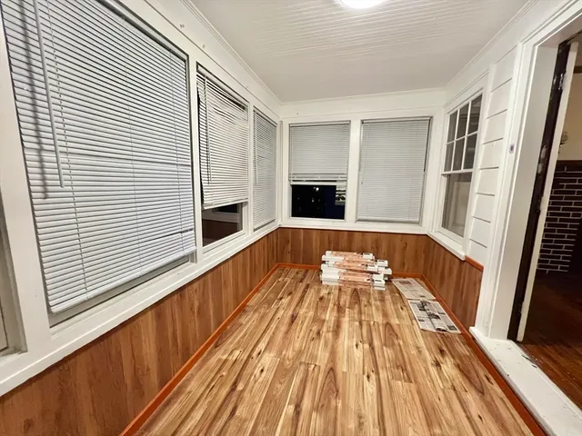 a view of a living room with wooden floor and fireplace