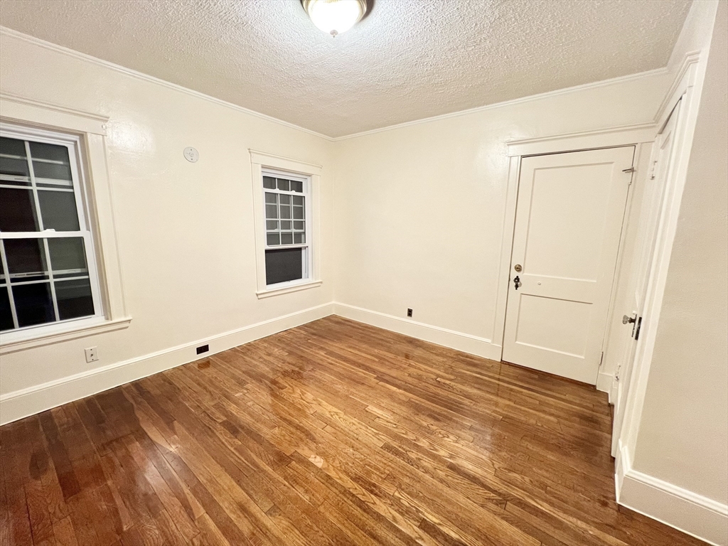 5 City View Road, Unit 2/F Boston, MA 02446 - Photo 8 of 14 an empty room with wooden floor and windows