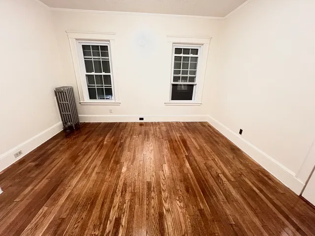 a view of a room with wooden floor and windows