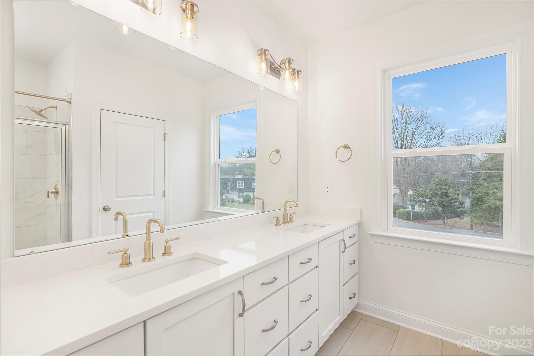 4013 Ashton Ridge Lane Charlotte, NC 28226 - Photo 11 of 13 a bathroom with double vanity sink a window and a mirror