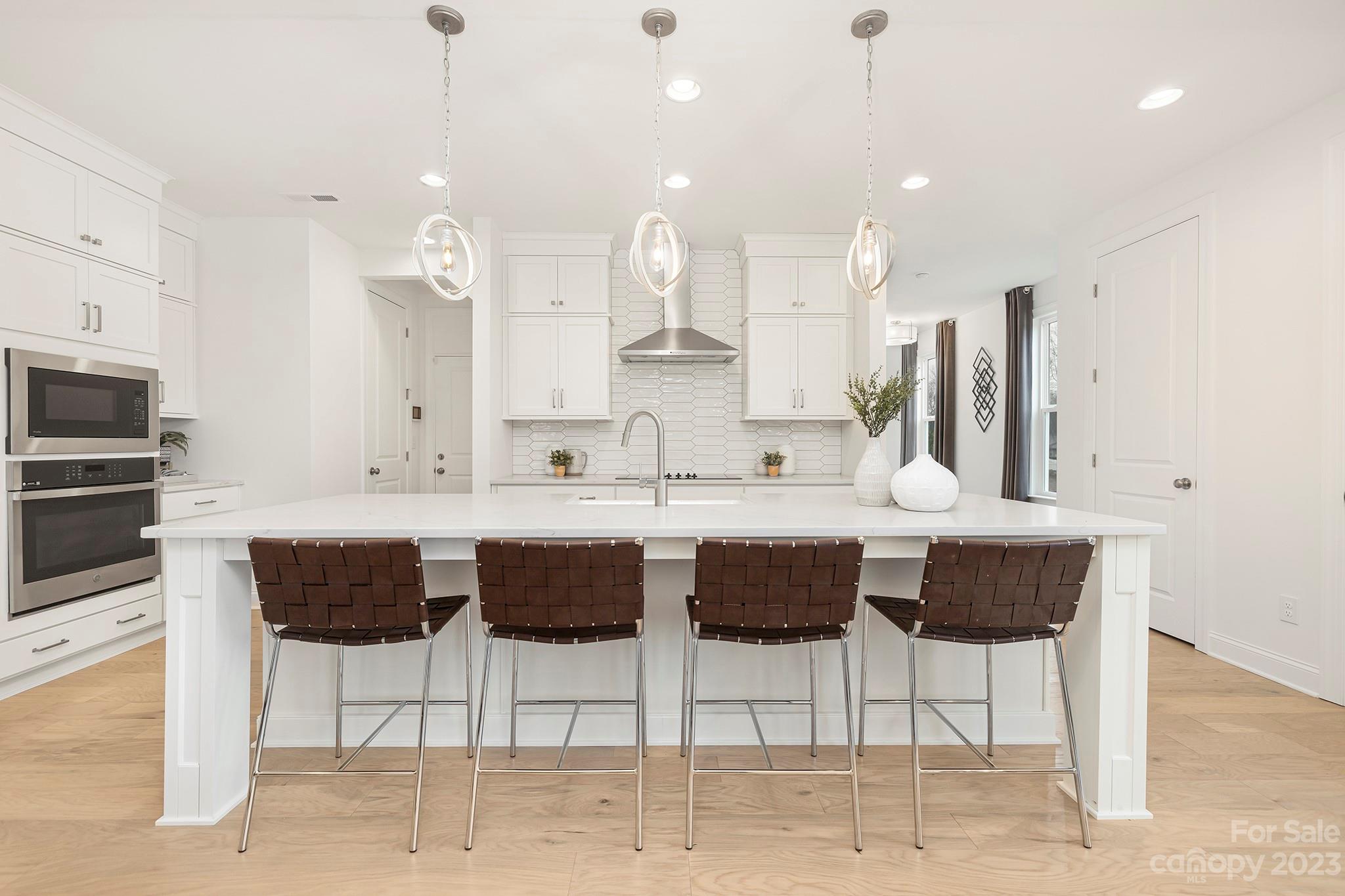 4013 Ashton Ridge Lane Charlotte, NC 28226 - Photo 2 of 13 a kitchen with stainless steel appliances kitchen island granite countertop a kitchen island and chairs in it
