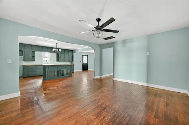 a view of an empty room with window and wooden floor