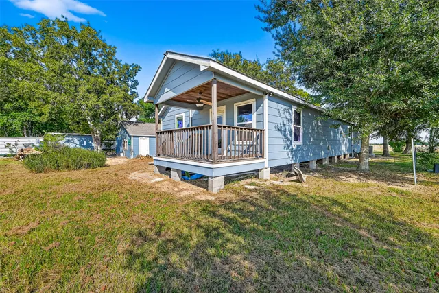 a view of a house with a small yard and wooden fence