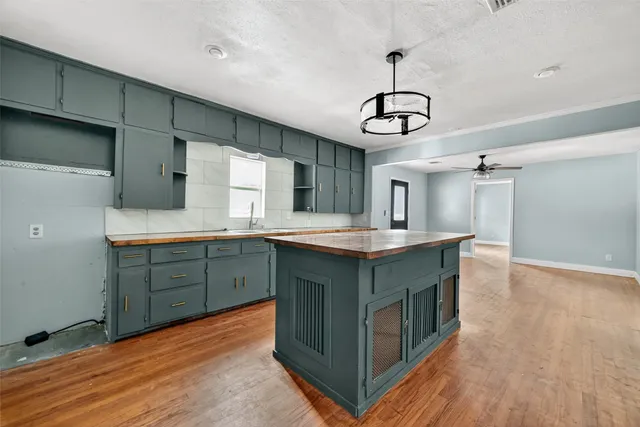 a kitchen with a sink cabinets and wooden floor