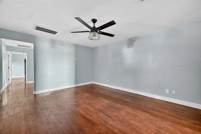 a view of an empty room with wooden floor