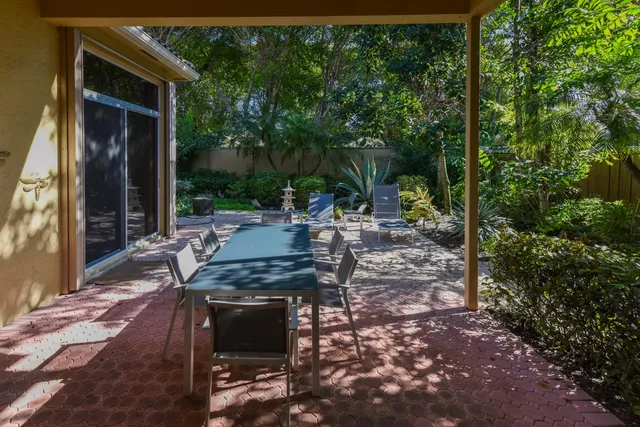 a view of a patio with table and chairs with wooden floor and fence