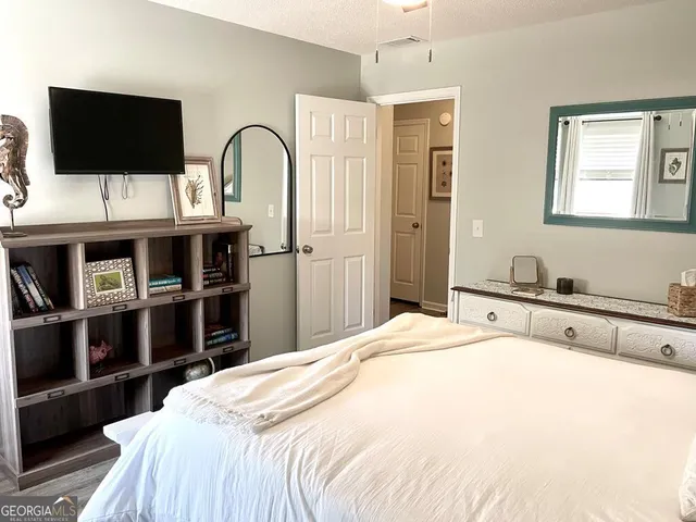 a bedroom with a bed and a flat screen tv