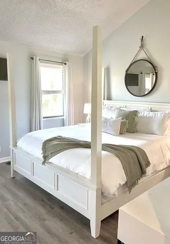a bedroom with a bed a mirror and a large window