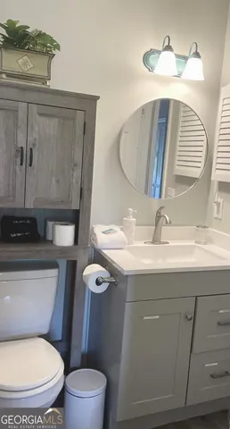 a bathroom with a toilet sink and mirror