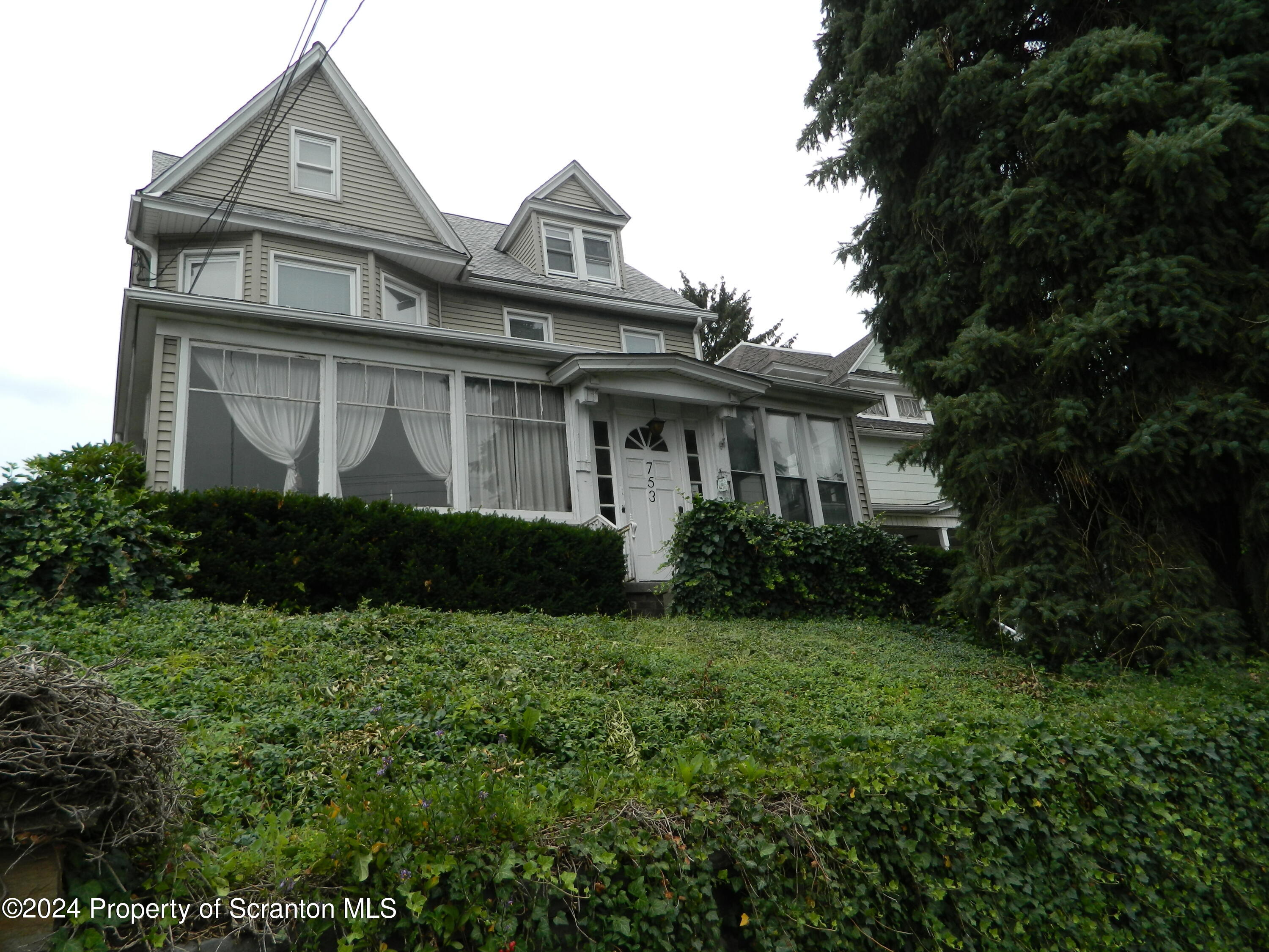 a view of a big house with a big yard and large trees