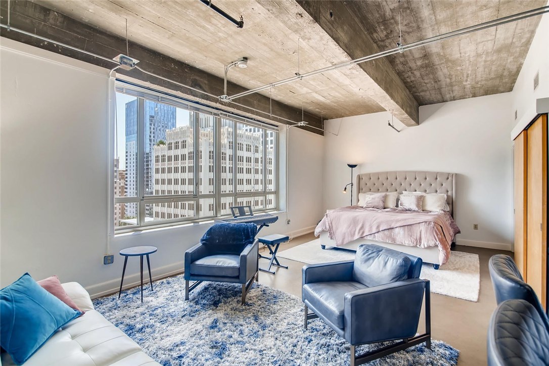 710 Colorado Street, Unit 9F Austin, TX 78701 - Photo 1 of 1 a bedroom with furniture and a large window