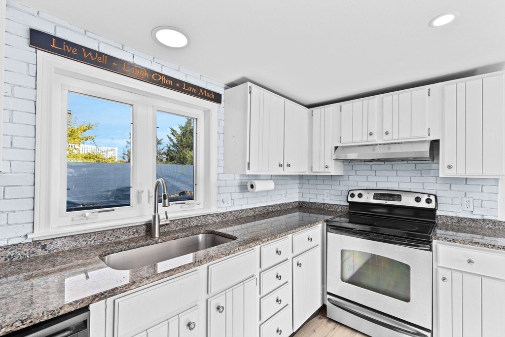 74 Cherry Street Marshfield, MA 02020 - Photo 10 of 35 a kitchen with granite countertop a sink stainless steel appliances white cabinets and a window
