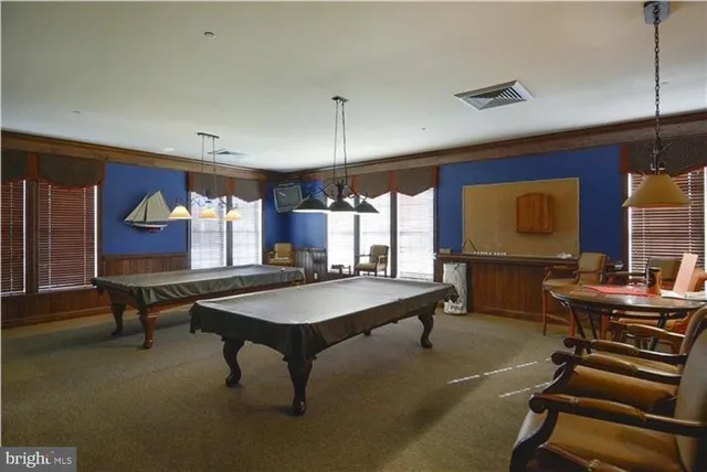 a room with furniture pool table table tennis table and a rug