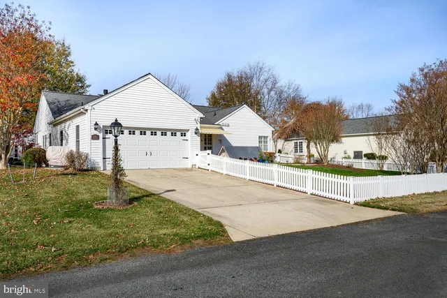 a view of a white house with a patio and a yard