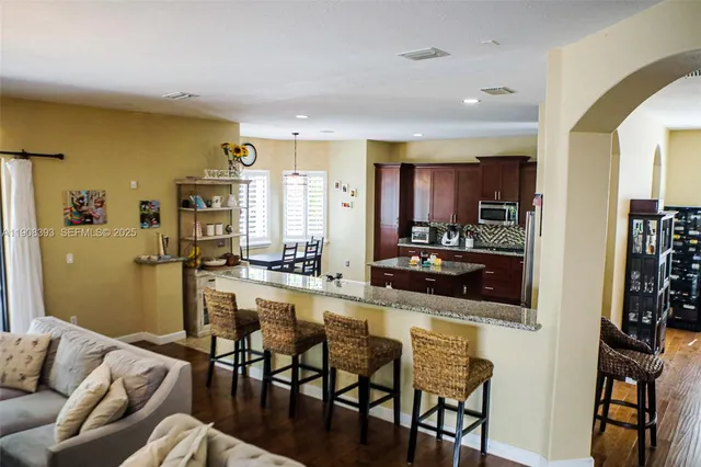 a kitchen with stainless steel appliances wooden floor dining table and chairs