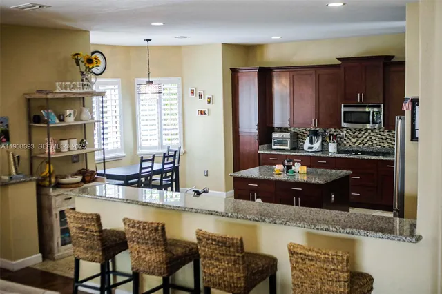 a kitchen with granite countertop a refrigerator and a stove top oven