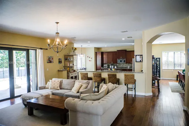 a living room with furniture dining area and a chandelier