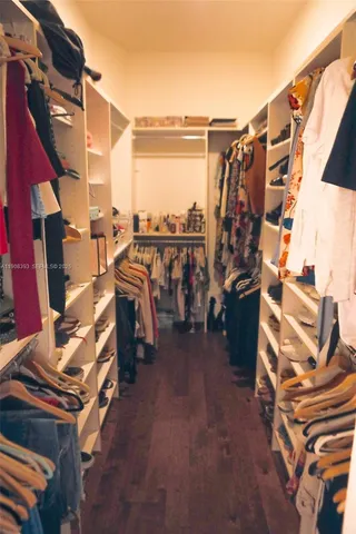 a view of walk in closet with clothes and shoes