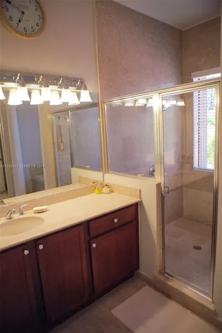 a bathroom with a sink mirror and a shower
