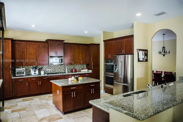 a kitchen with stainless steel appliances granite countertop a stove refrigerator and cabinets
