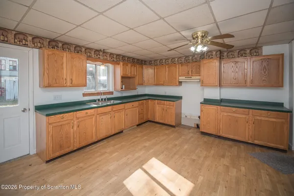 a large kitchen with stainless steel appliances granite countertop a sink window and cabinets