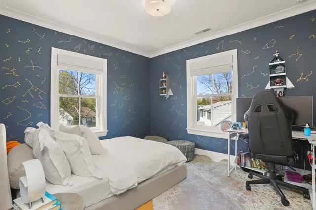 a bedroom with a bed and windows