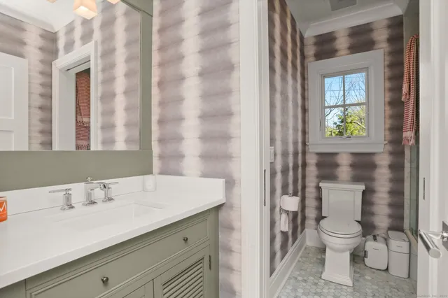 a bathroom with a granite countertop sink a toilet and a shower