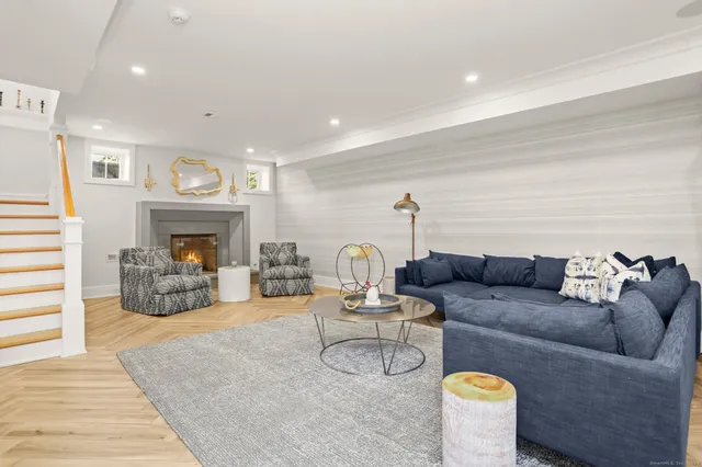 a living room with furniture a fireplace and a ceiling fan