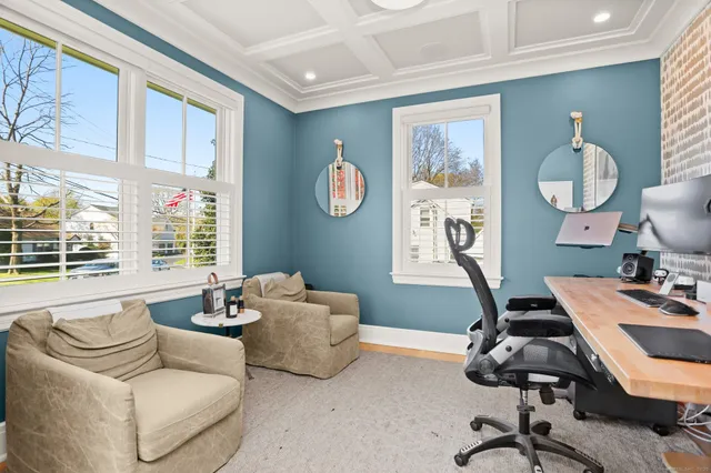 a view of a workspace with furniture and a window