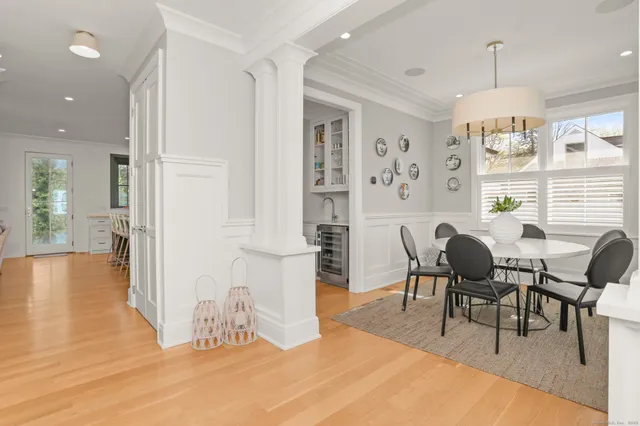 a dining room with wooden floor and a chandelier