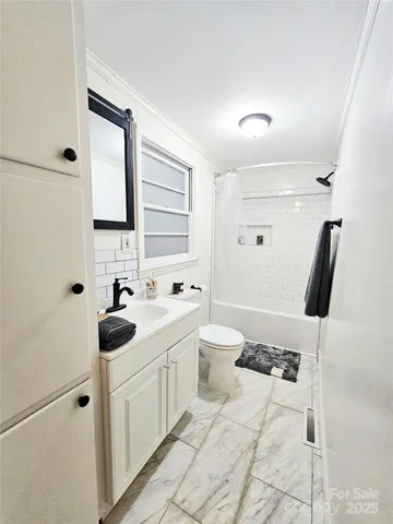 a white bath tub sitting next to a white sink and a toilet