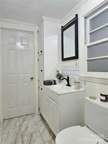 a bathroom with a toilet sink and mirror