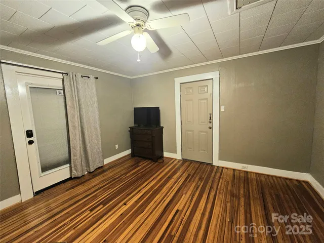 a view of an empty room with wooden floor