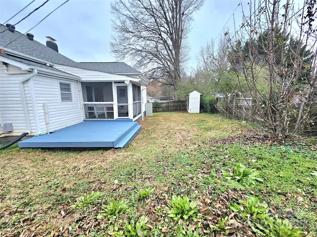 a view of a house with backyard and trees