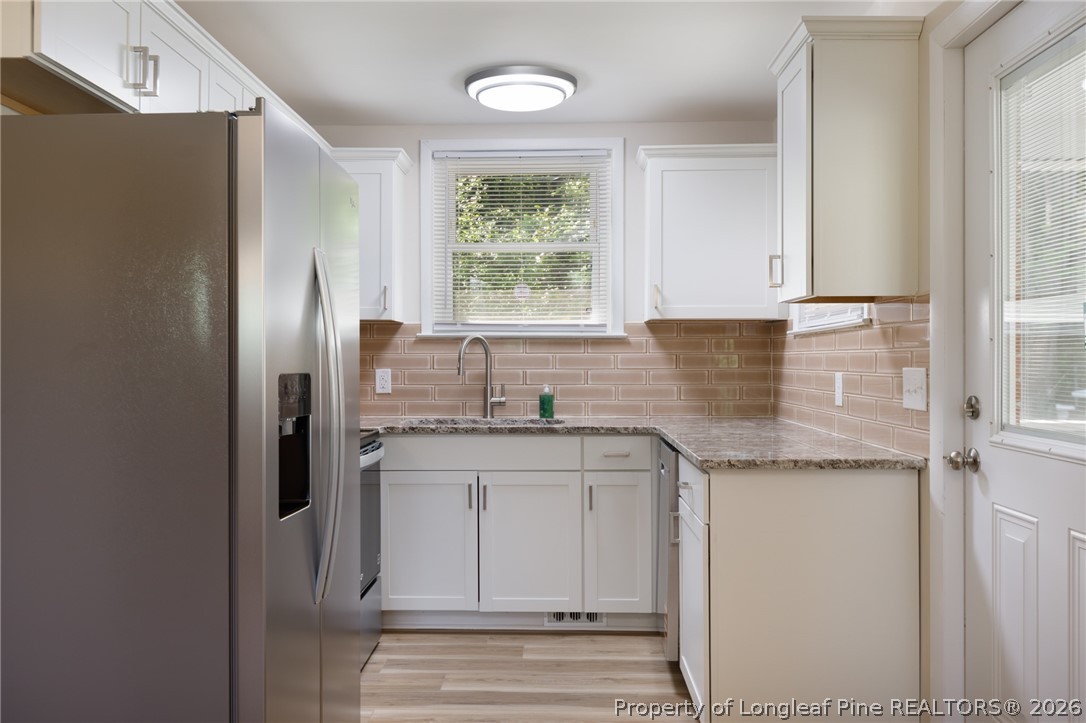 201 Scarborough Street Spring Lake, NC 28390 - Photo 7 of 26 a kitchen with granite countertop a sink cabinets and a window