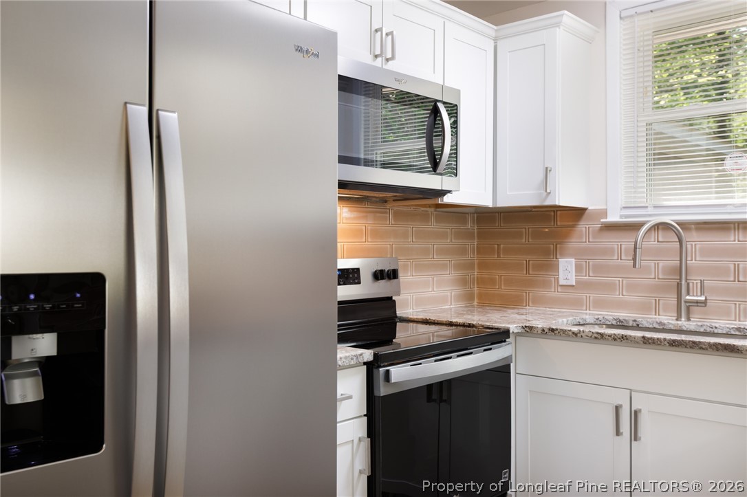 201 Scarborough Street Spring Lake, NC 28390 - Photo 8 of 26 a kitchen with stainless steel appliances granite countertop a sink stove and microwave