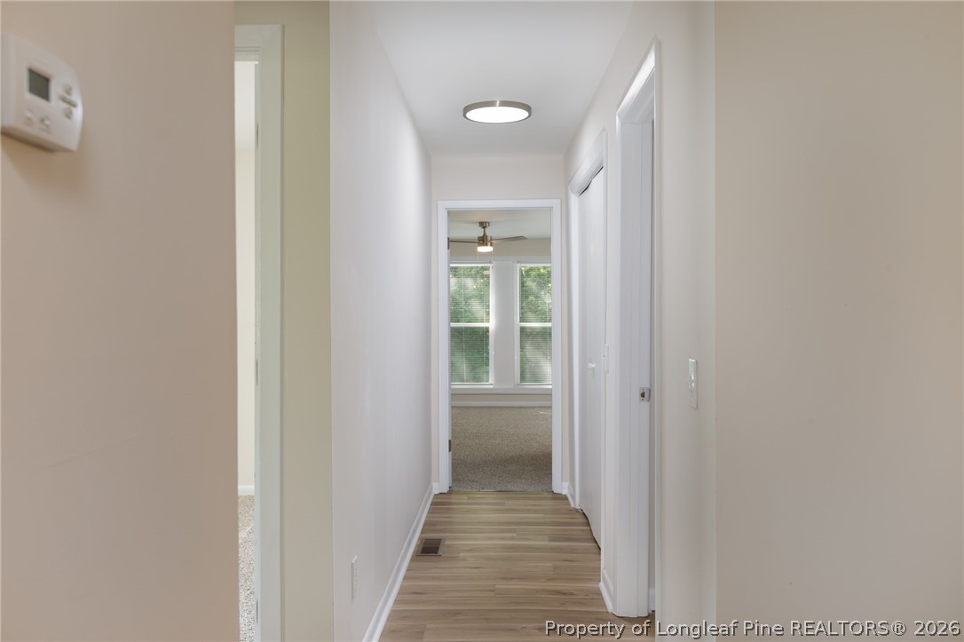 201 Scarborough Street Spring Lake, NC 28390 - Photo 10 of 26 a view of a hallway with wooden floor and a bathroom