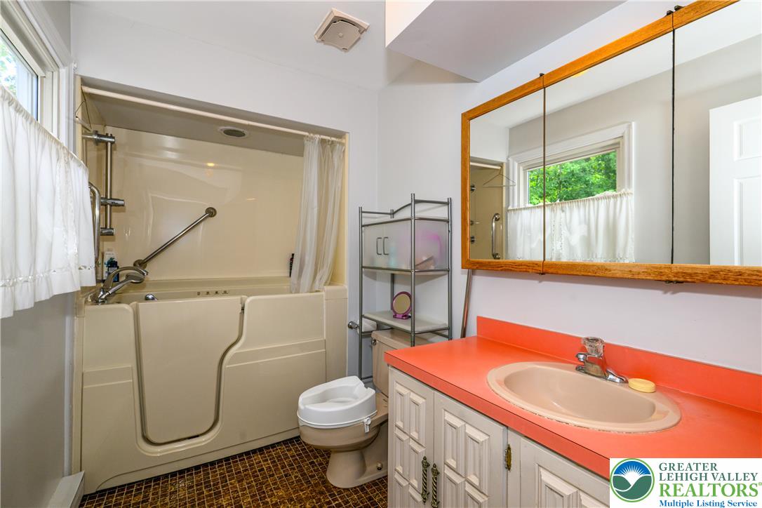2516 Rachael Lane Orefield, PA 18069 - Photo 20 of 45 Accessible bathroom featuring a walk-in tub with grab bars and a vanity with a large mirror.