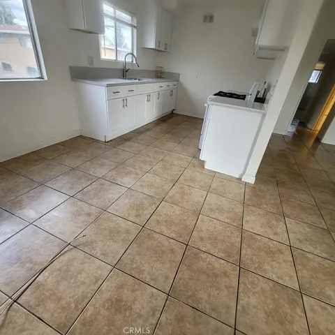 a kitchen with a sink cabinets and a stove top oven