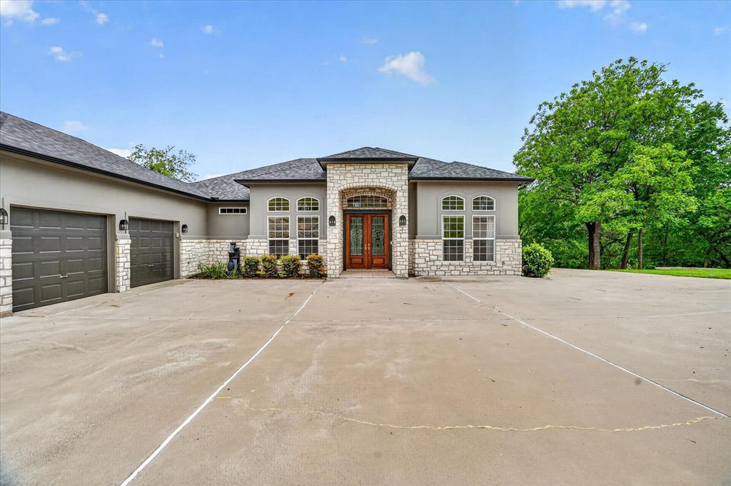 9704 Ravenswood Road Granbury, TX 76049 - Photo 9 of 40 a view of a house with a yard and garage