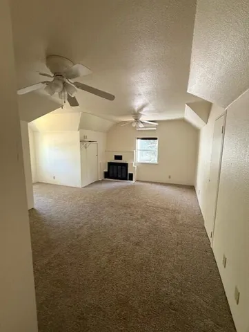 a view of a big room with windows and a ceiling fan