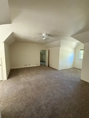 a view of a room that has a large window with front of red door