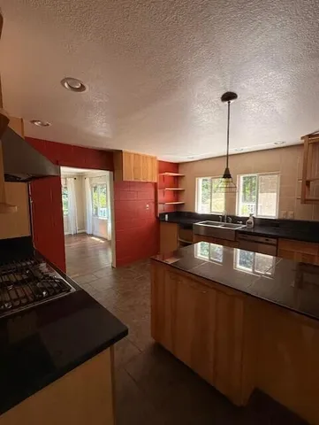 a kitchen with stainless steel appliances granite countertop a sink a stove and a refrigerator