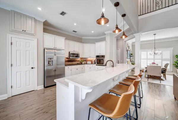 a large kitchen with lots of counter space and wooden floor